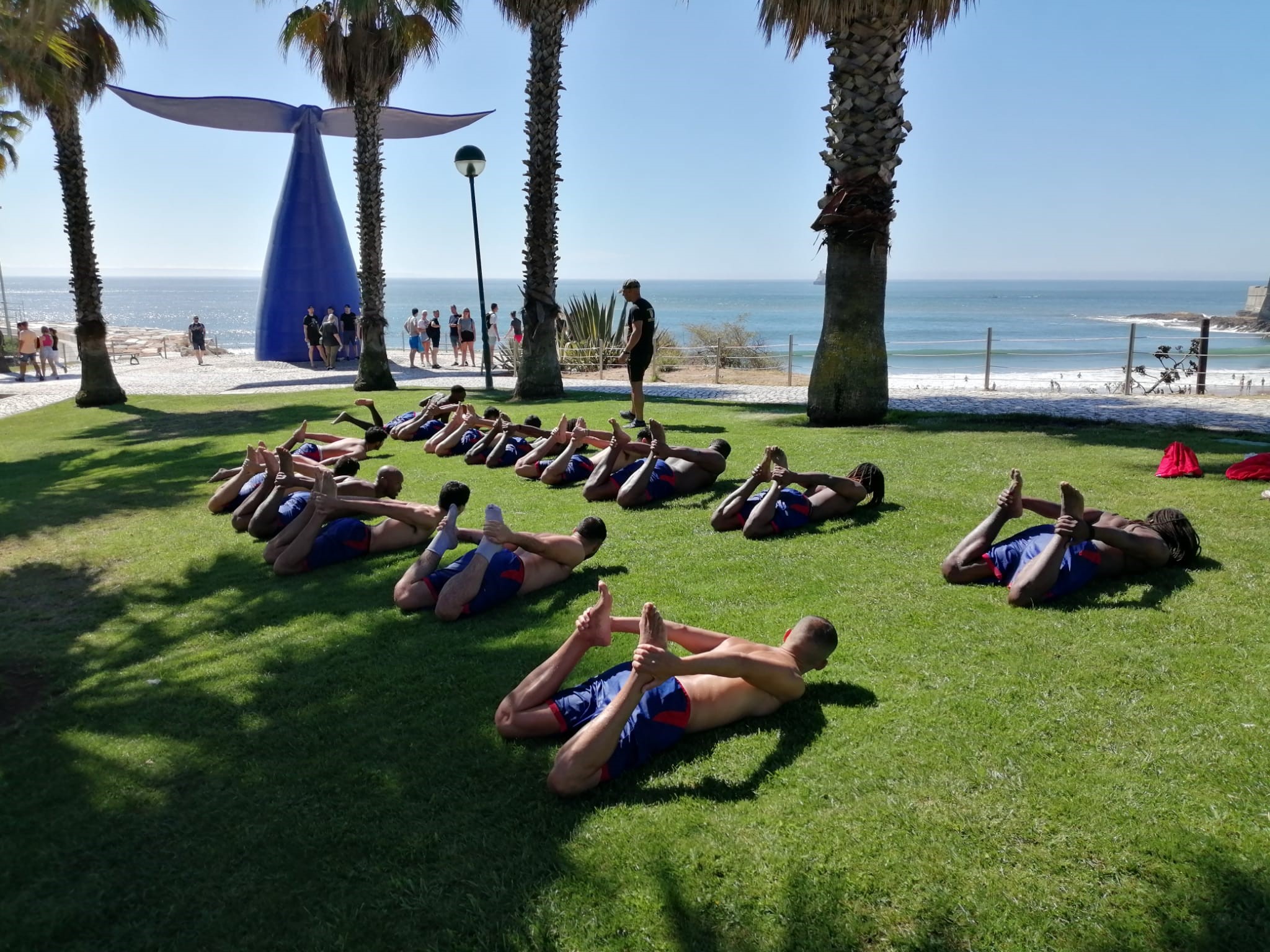 equipa desportiva a fazer alongamentos após atividade de team building