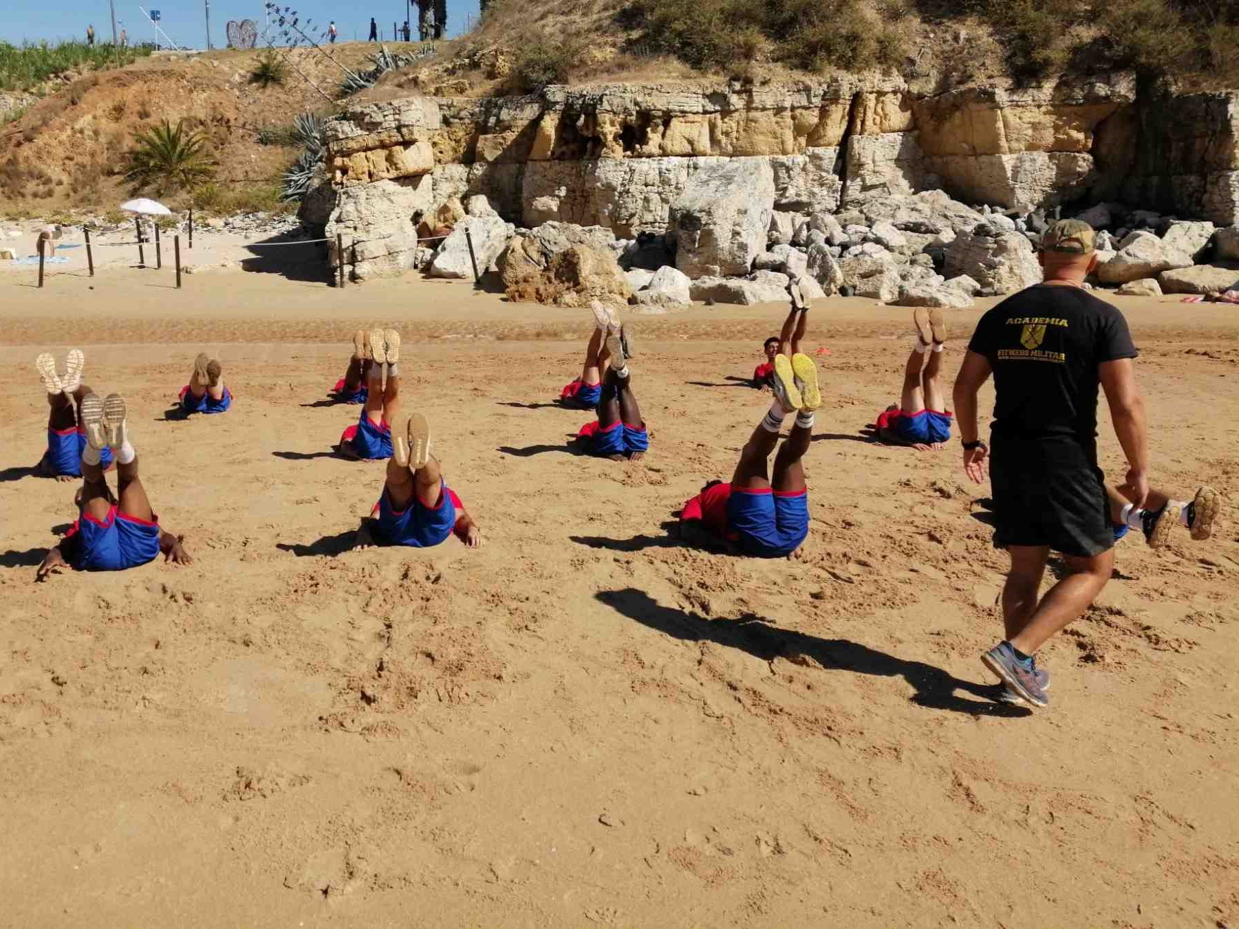 Equipa de clube desportivo a realizar exercício de grupo com foco na gestão do esforço e metodologia militar