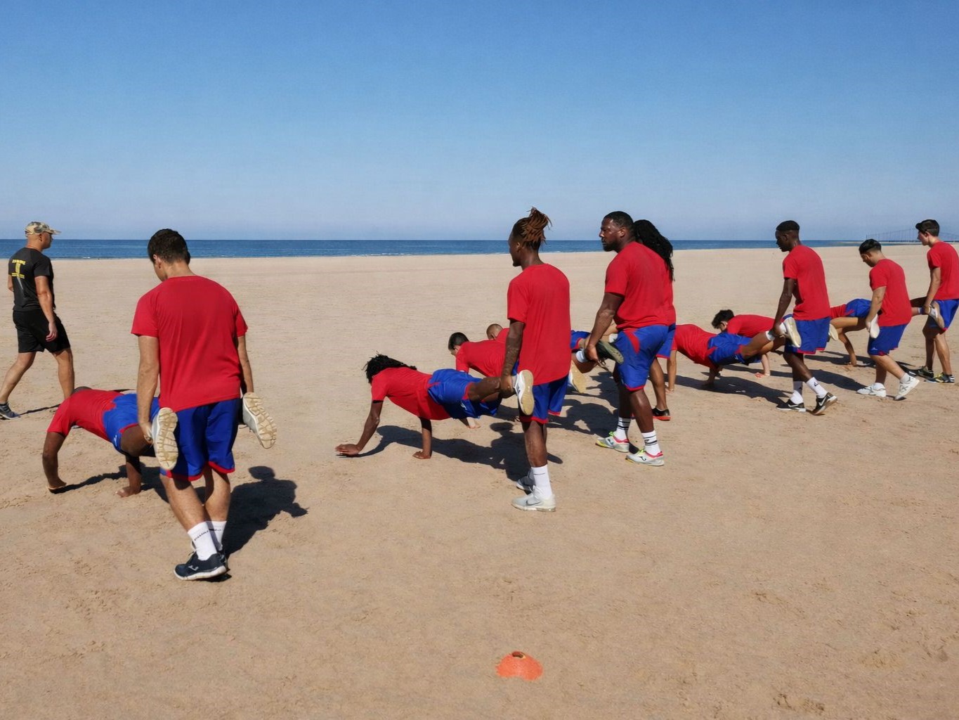 equipa de atletas a fazer jogo de desenvolvimento coletivo na praia