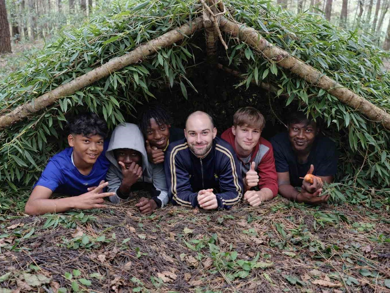 Grupo de jovens atletas de clube desportivo a participar numa atividade estratégica em ambiente natural
